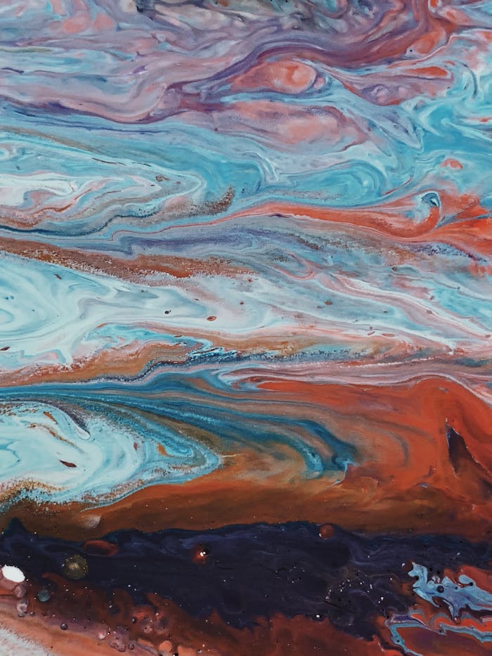 A vibrant abstract painting featuring swirling blue, orange, and white fluid patterns with a dynamic texture.